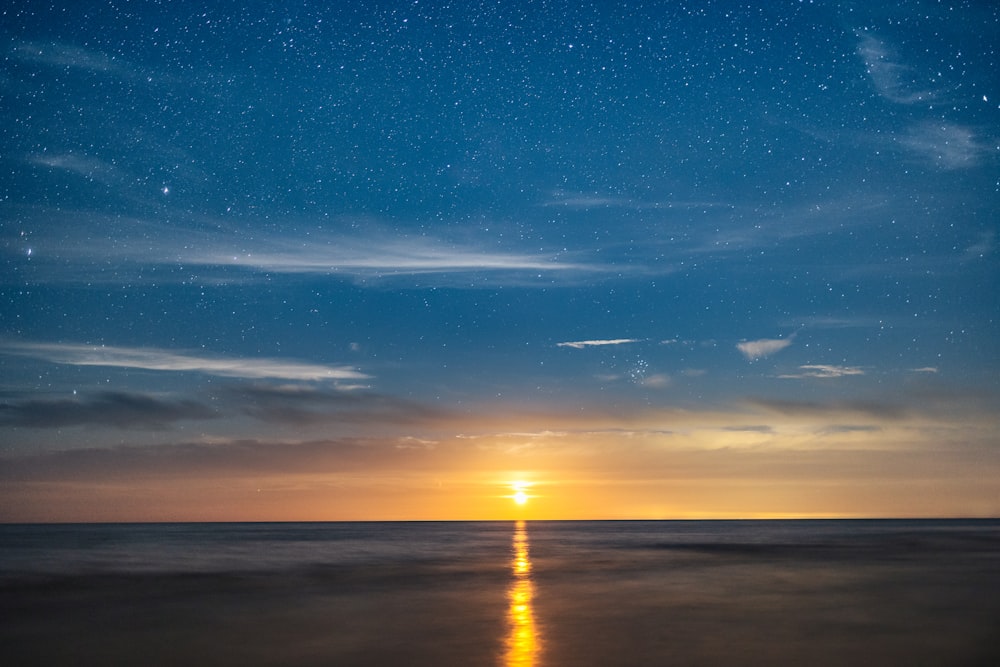 the sun is setting over the ocean on a clear day