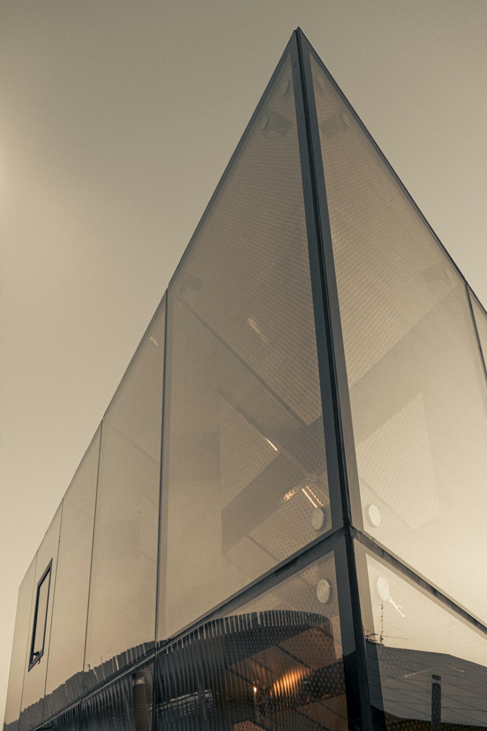 a large glass building with a clock tower in the background