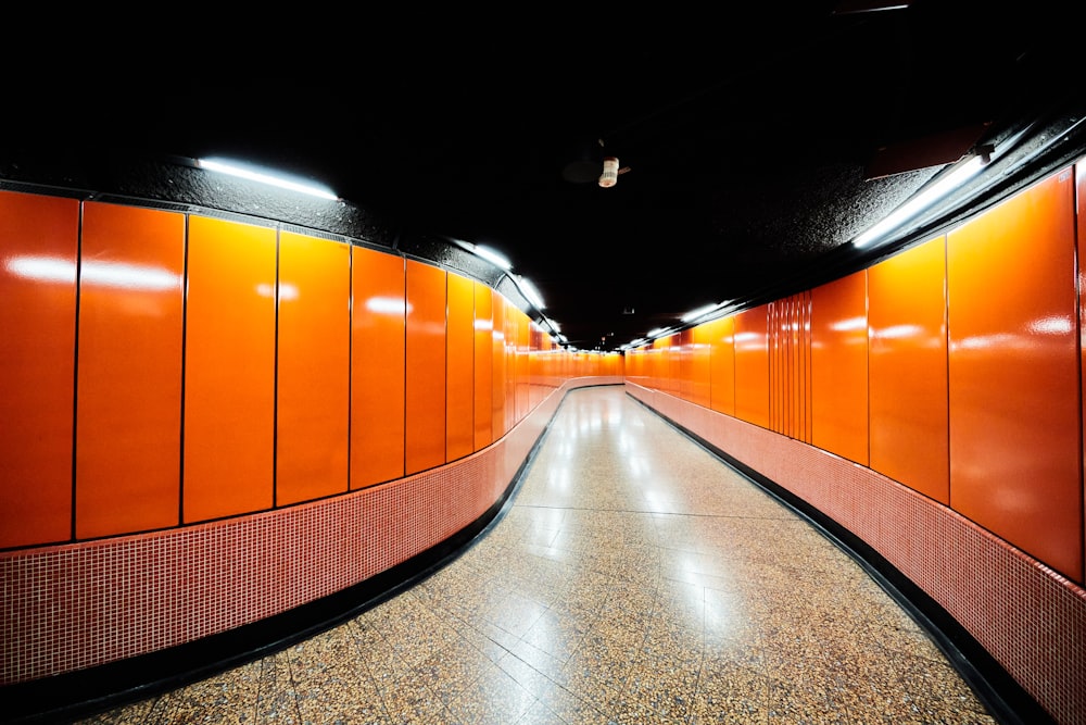 a long hallway with orange walls and a tiled floor