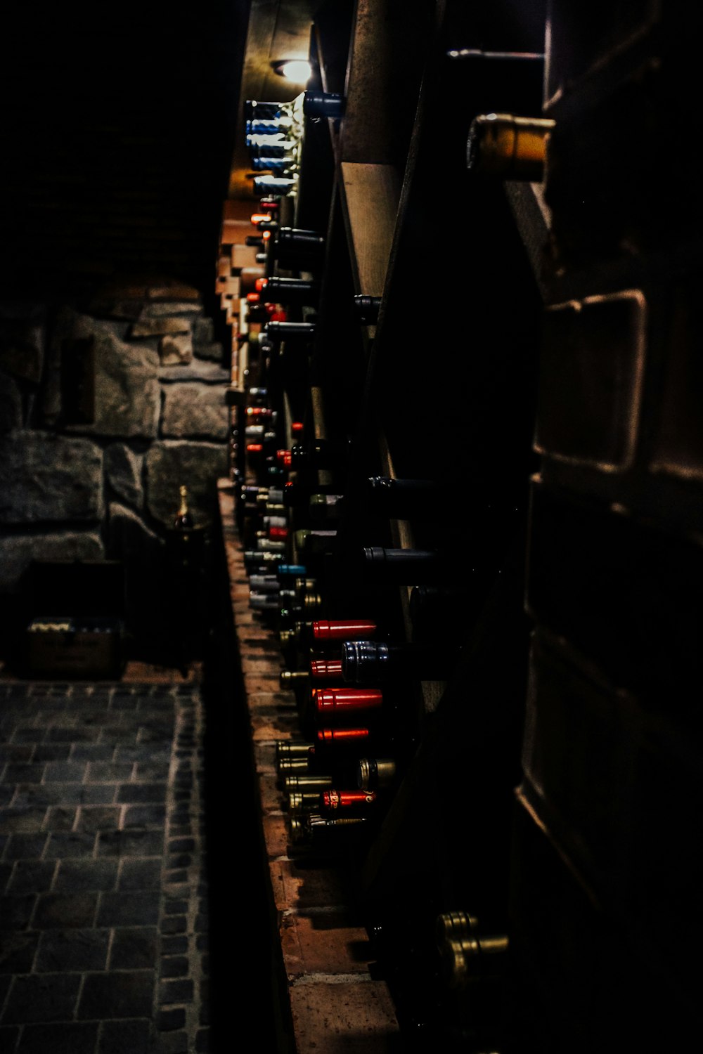 a long row of wine bottles in a dark room