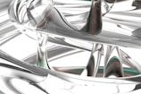 Intricate and abstract network of metallic and glass-like structures with a fluid, twisting formation. The surfaces reflect and refract light, creating a sense of depth and complexity.