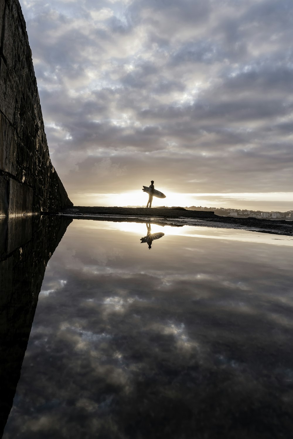 a person with a surfboard standing in the water