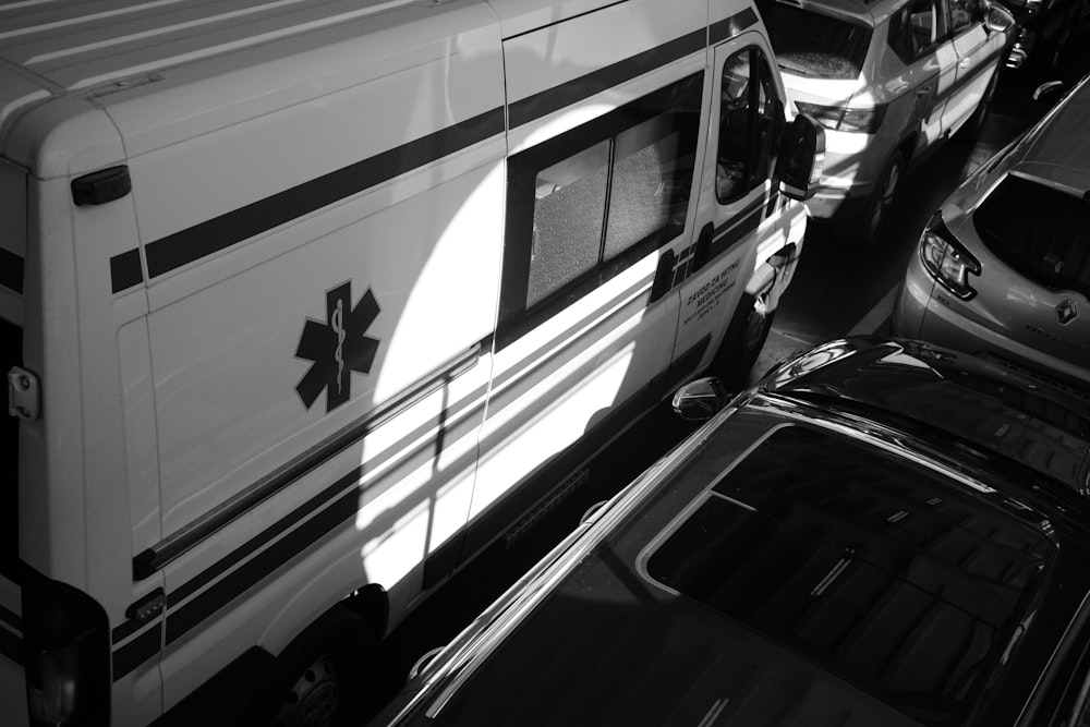 a black and white photo of cars and an ambulance