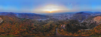 A panoramic view of the sprawling GTA 6 game world at sunset, showing diverse landscapes.