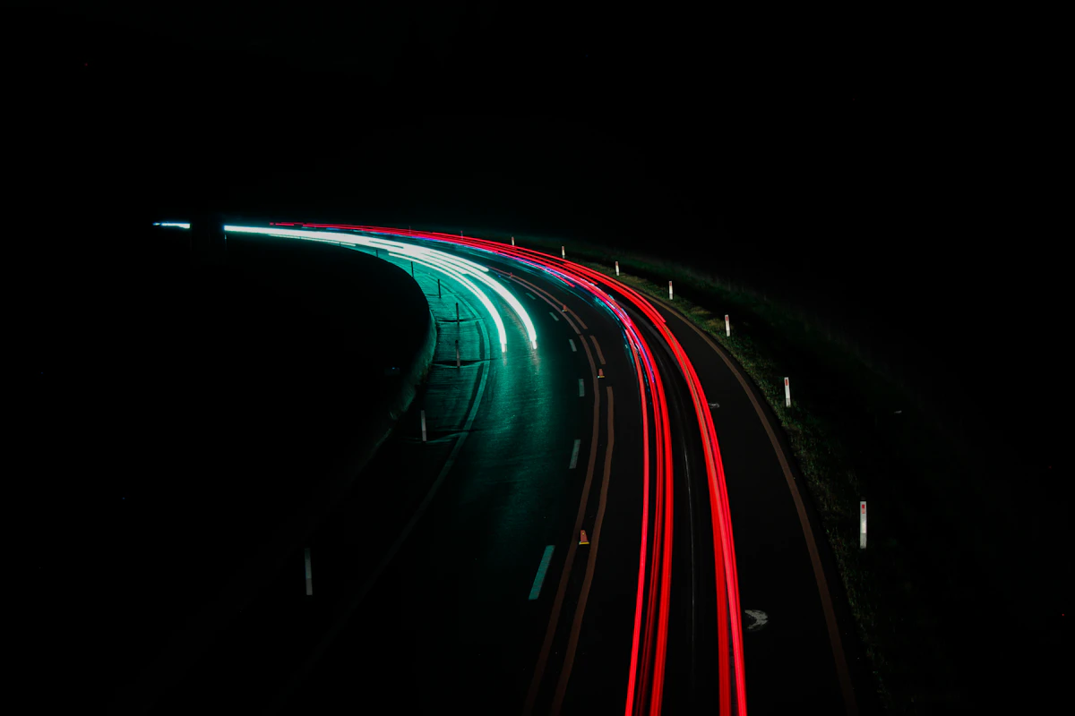 Jalan raya pada malam hari dengan pencahayaan lampu kendaraan