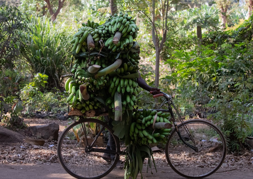 a person riding a bike with a bunch of bananas on it