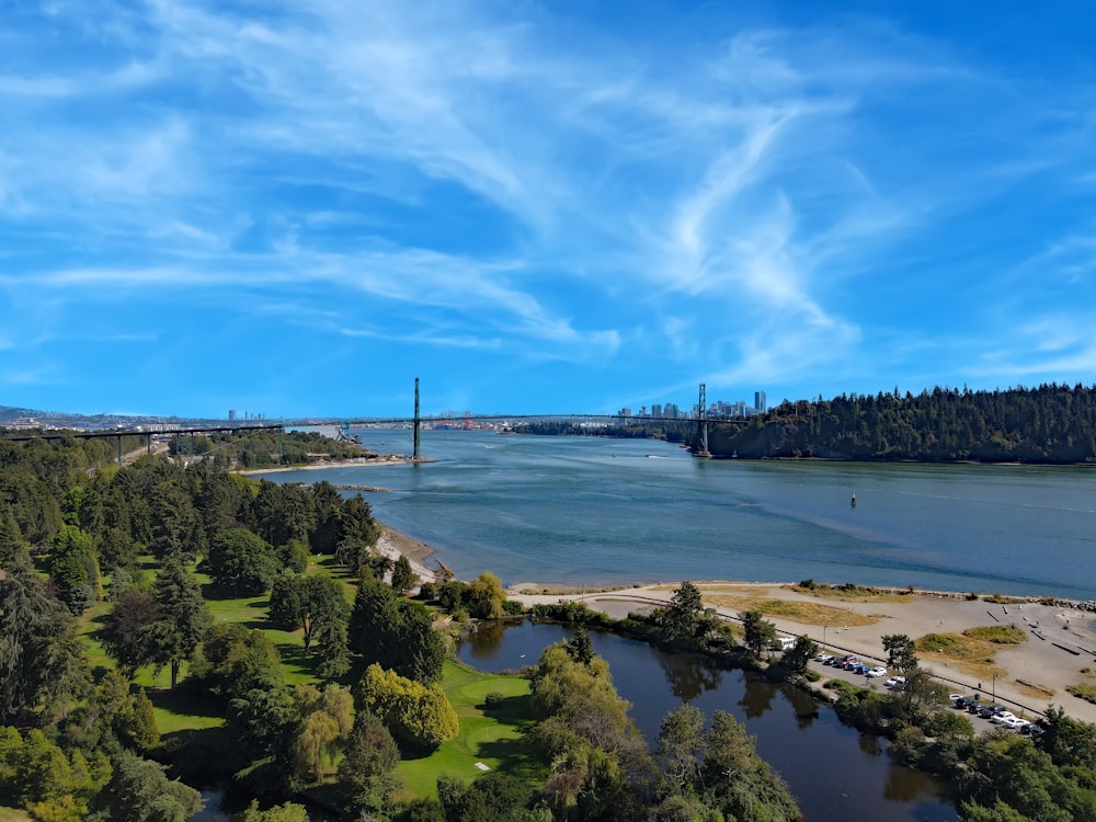 an aerial view of a river with a bridge in the background