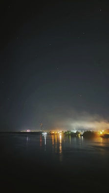 A peaceful evening scene with Sarfraz Azam reflecting by a window with city lights.