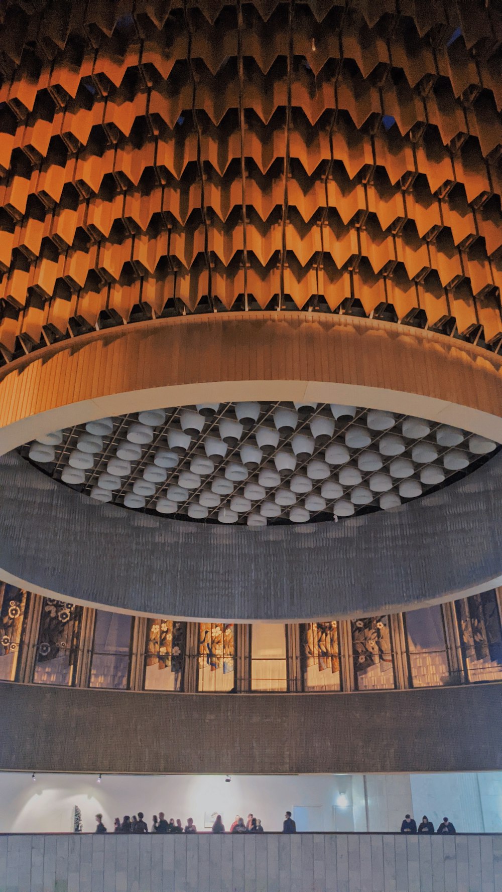 Un grand bâtiment avec un plafond circulaire et de nombreuses personnes qui s’y promènent