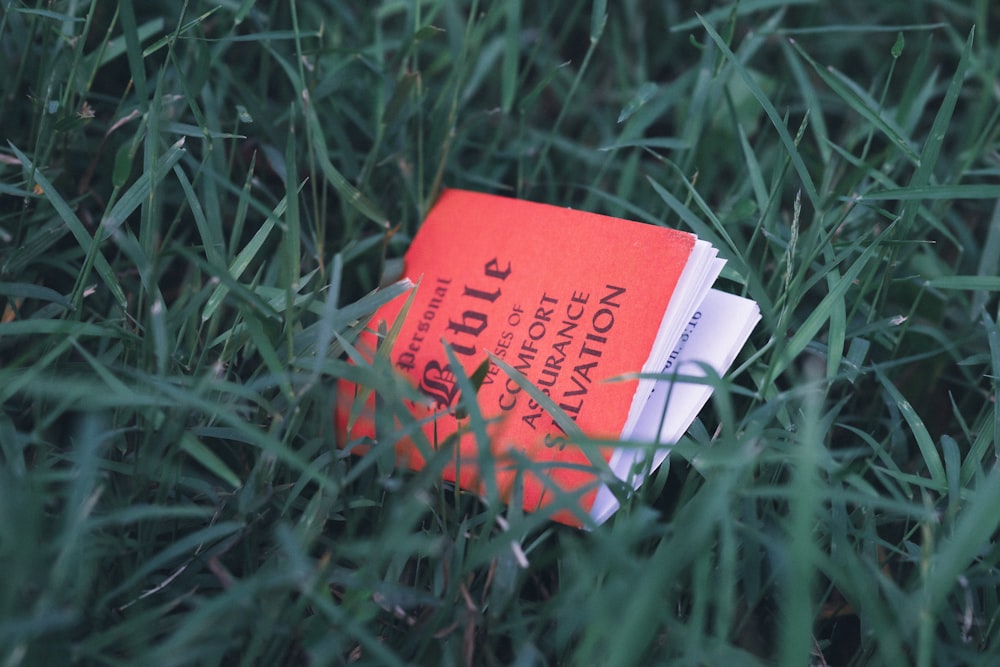 a book sitting in the middle of a field of grass