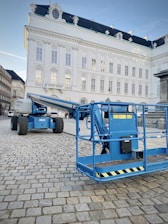 a large blue crane sitting in front of a white building