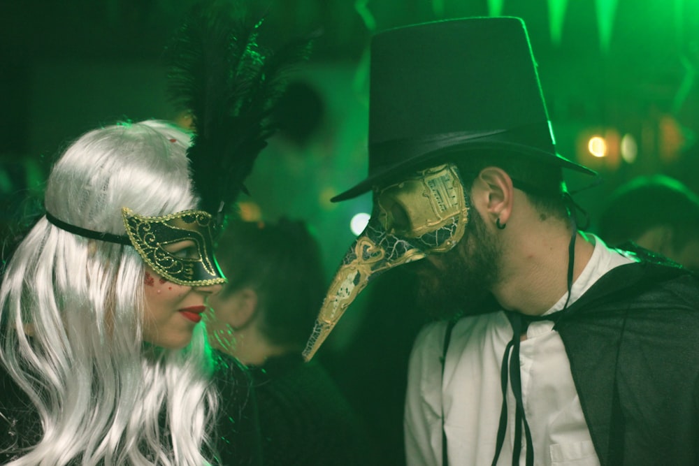 a man and a woman wearing masks at a party