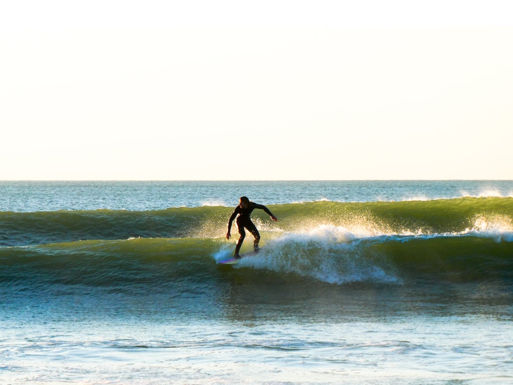 a man riding a wave on top of a surfboard