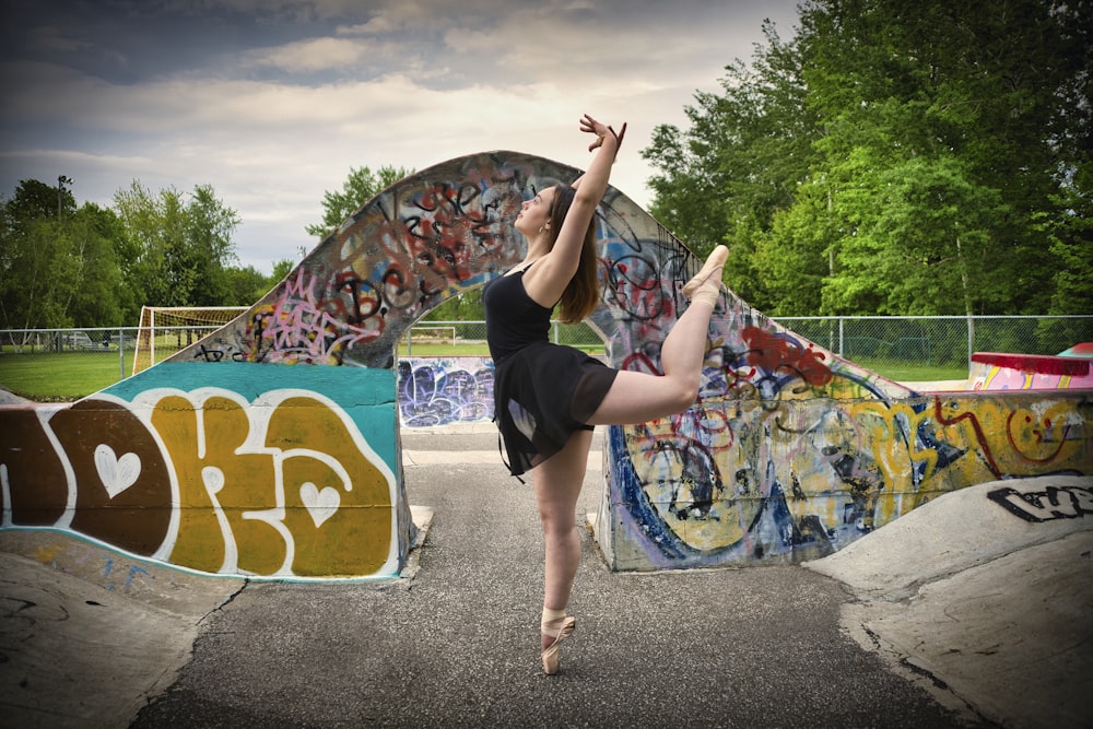 a woman in a black leotard doing a trick on a skateboard