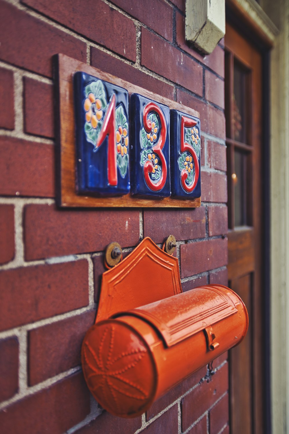 a red brick wall with a mailbox mounted to it