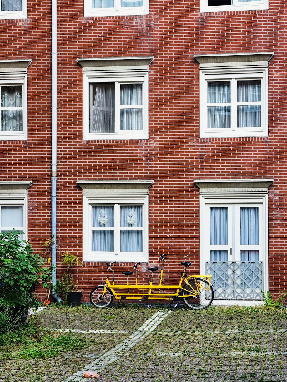 a yellow bike parked in front of a brick building