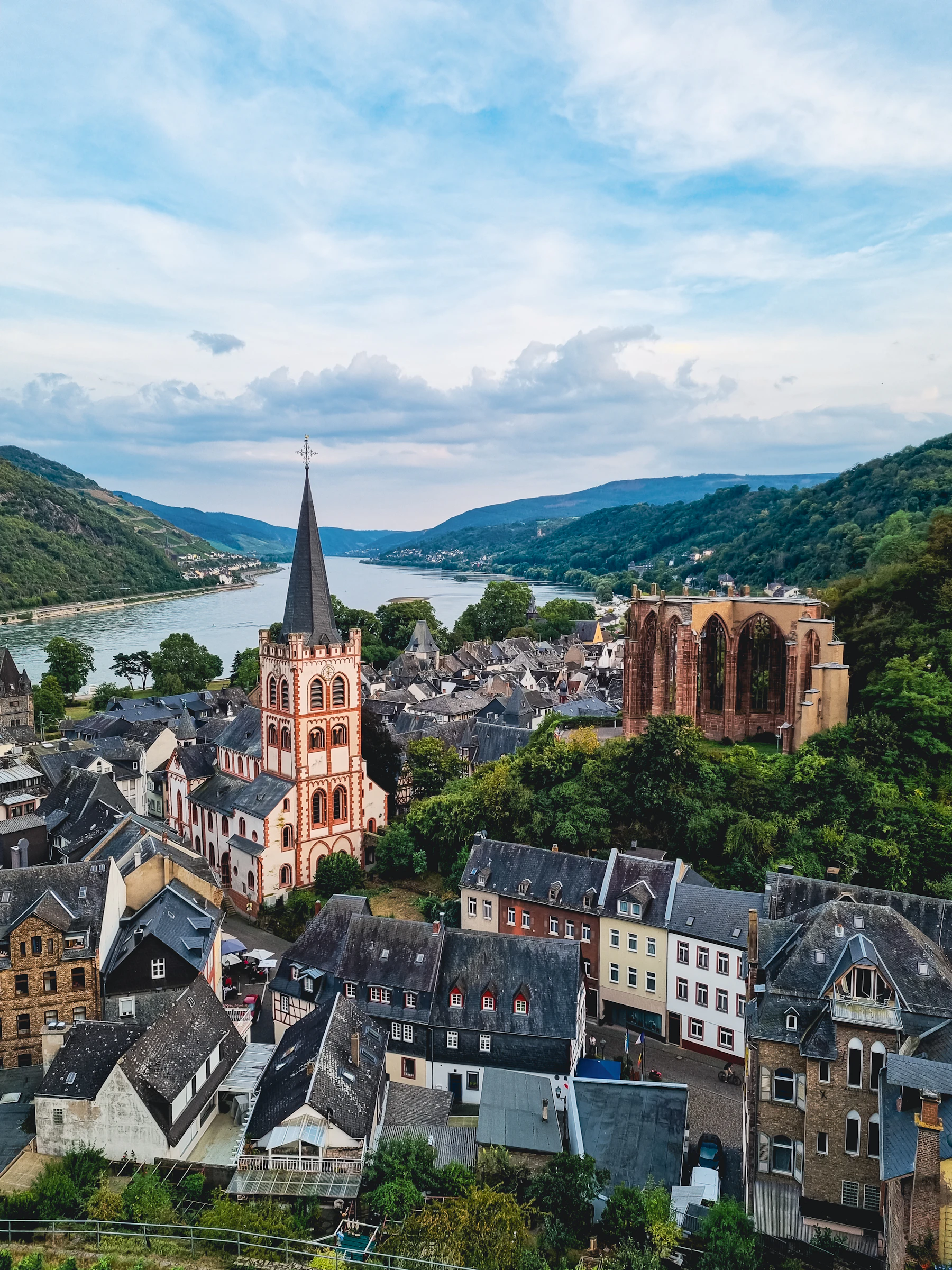 A town stands beside a broad river under a pale sky.