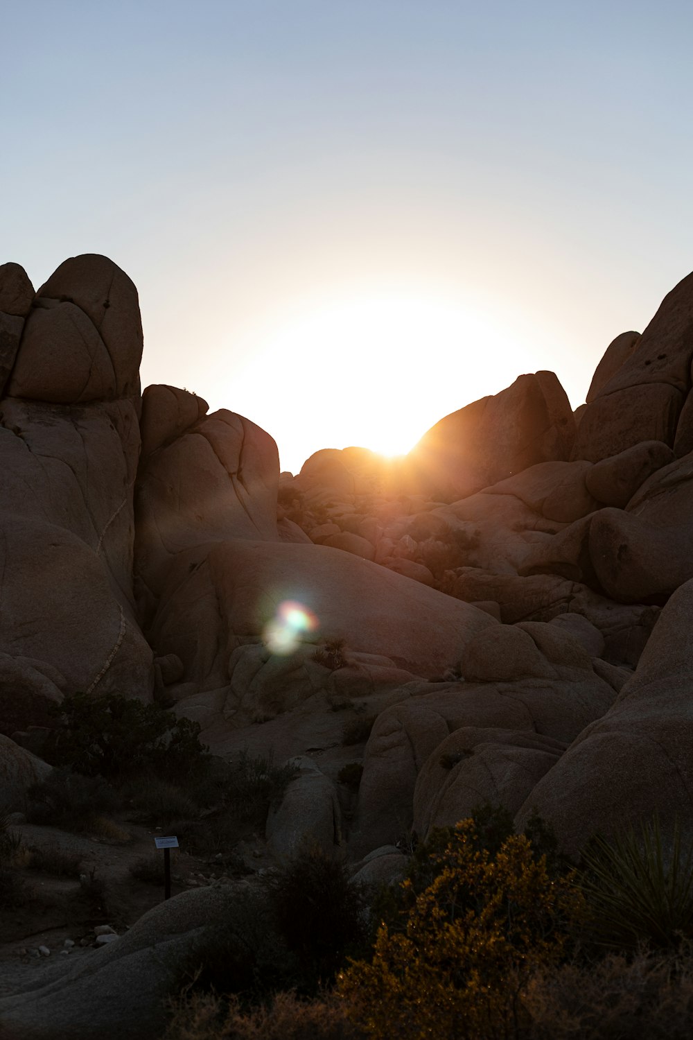 the sun is setting over the rocks in the desert