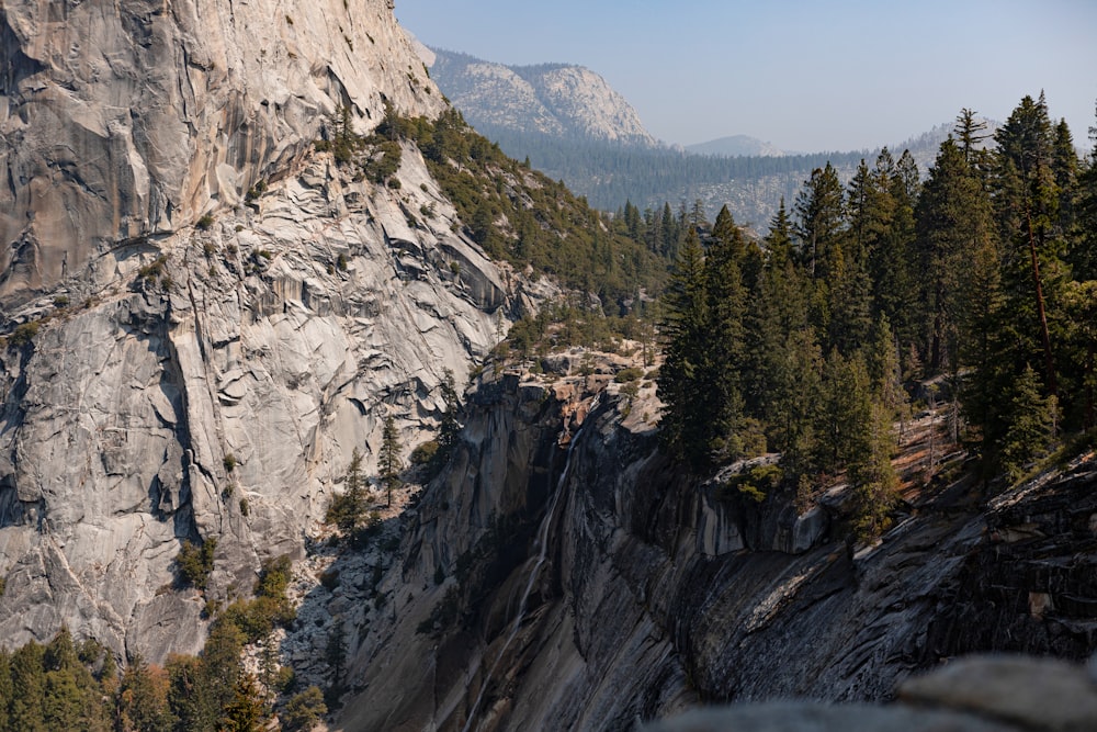 a view of a rocky mountain with trees on the side