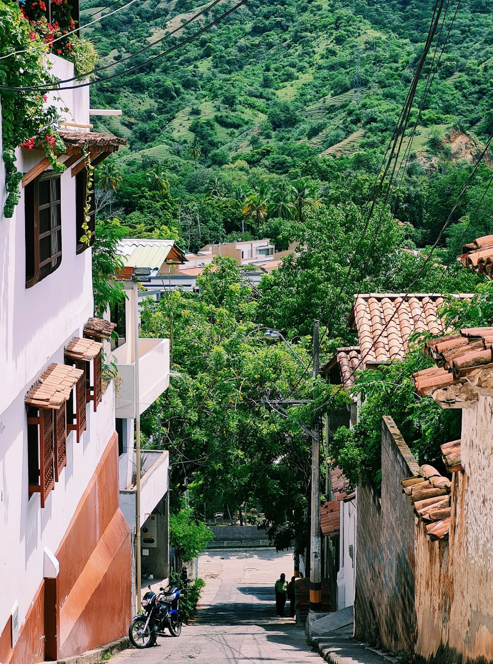 a narrow street with a mountain in the background