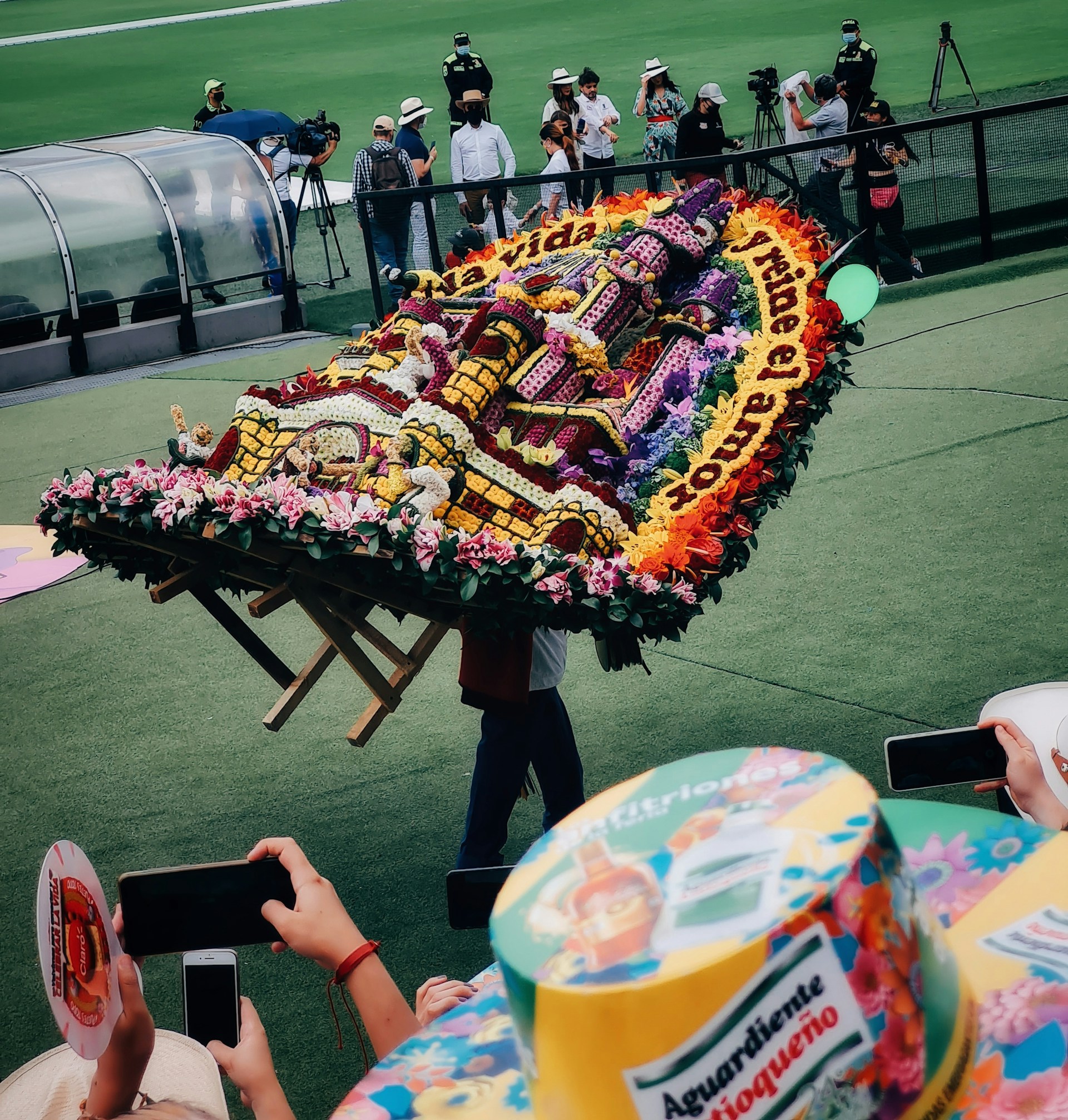 a man carrying a large cake on top of a field