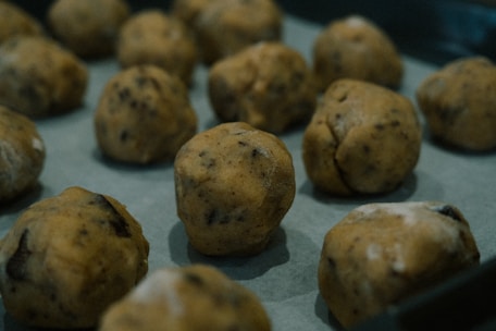 Artisanal pão de queijo dough balls neatly arranged on a baking tray ready for freezing.