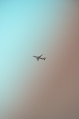 a plane flying in the sky on a hazy day