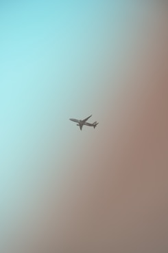 a plane flying in the sky on a hazy day