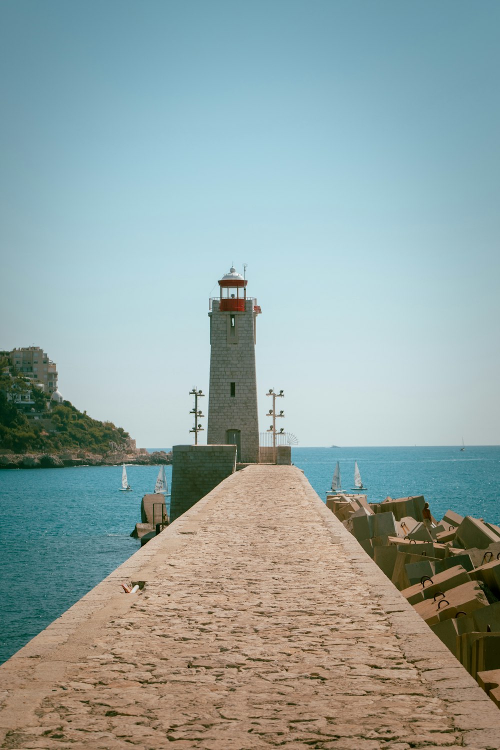 a light house sitting on top of a pier next to the ocean