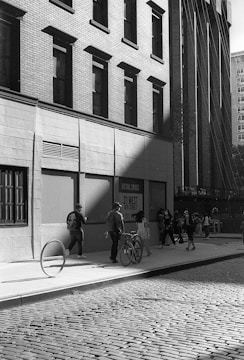 Black and white candid photo of a street scene with people.
