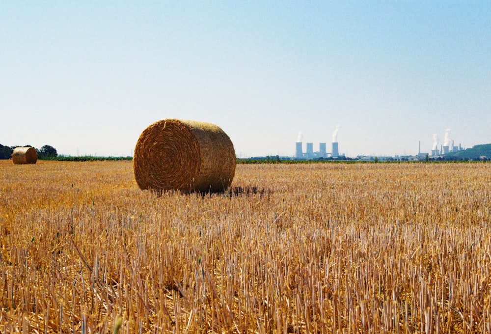 a field with hay bales in the foreground