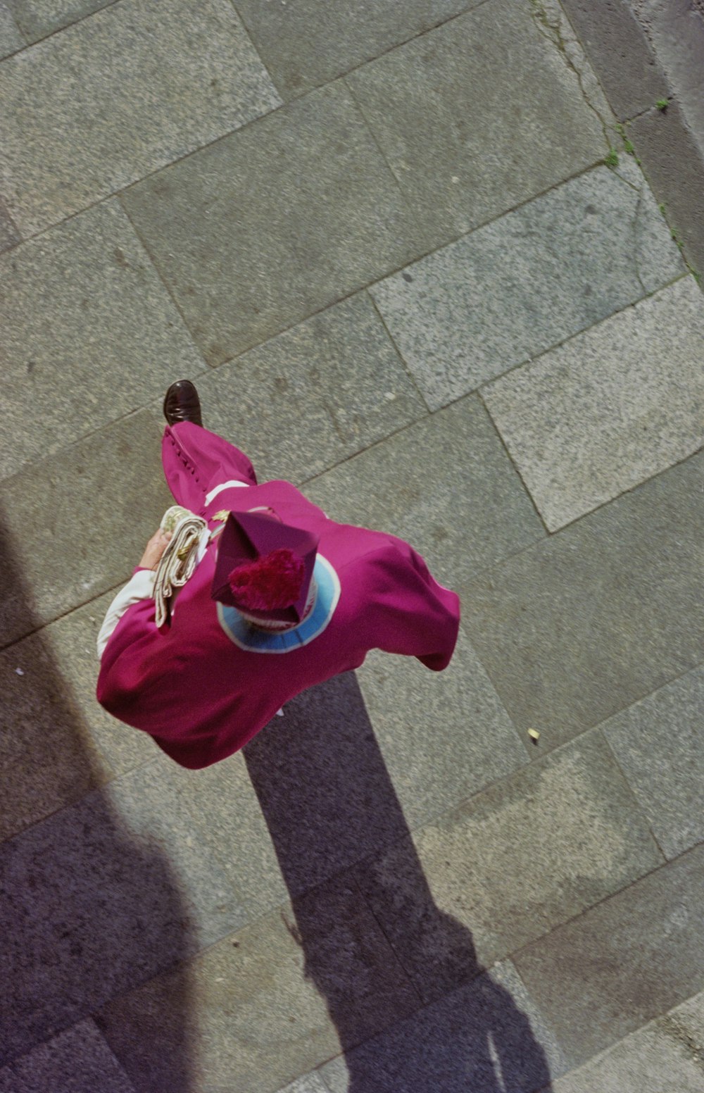 a person standing on a sidewalk with a hat on