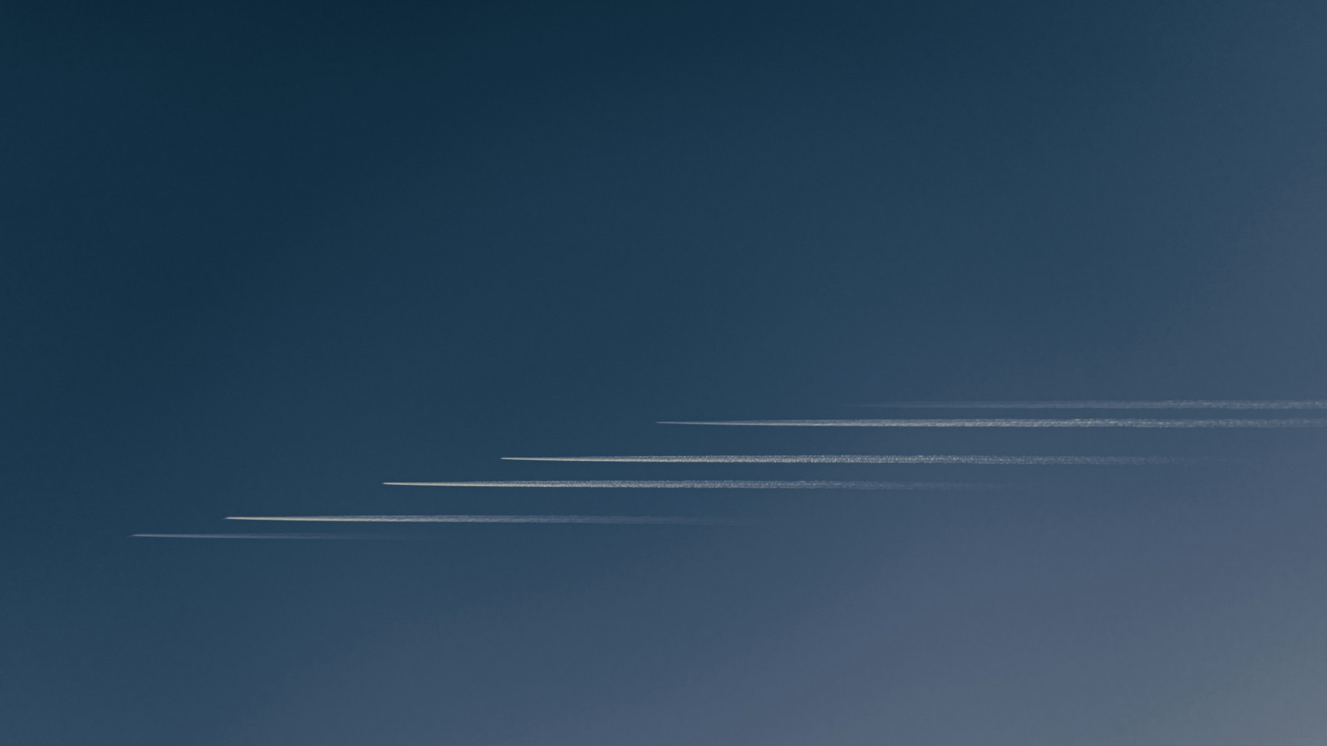 a group of airplanes flying through a blue sky