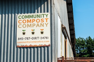 a sign on the side of a building that says community compost company