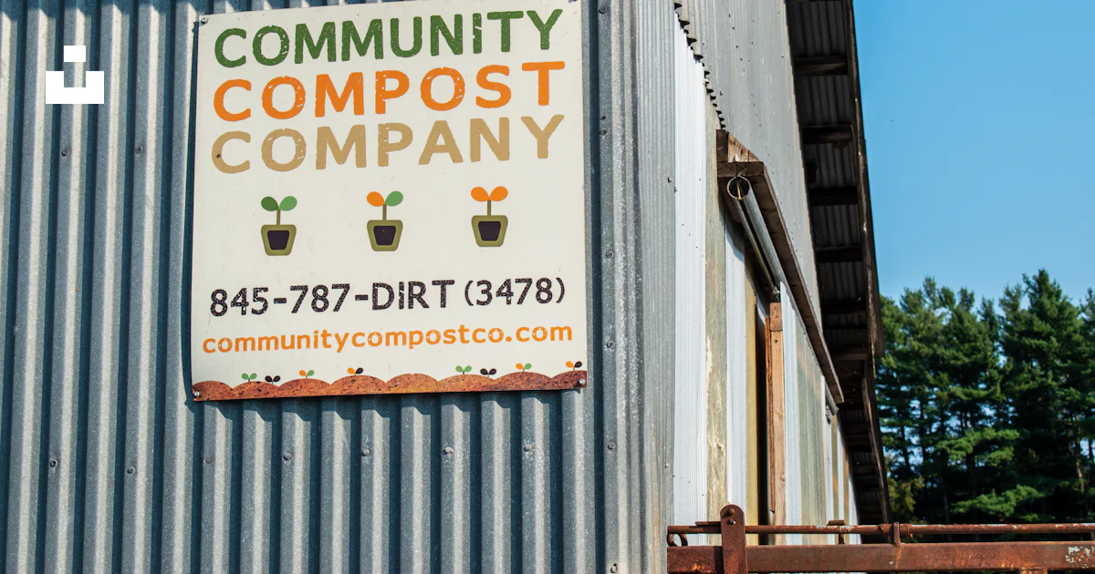 A sign on the side of a building that says community compost company ...