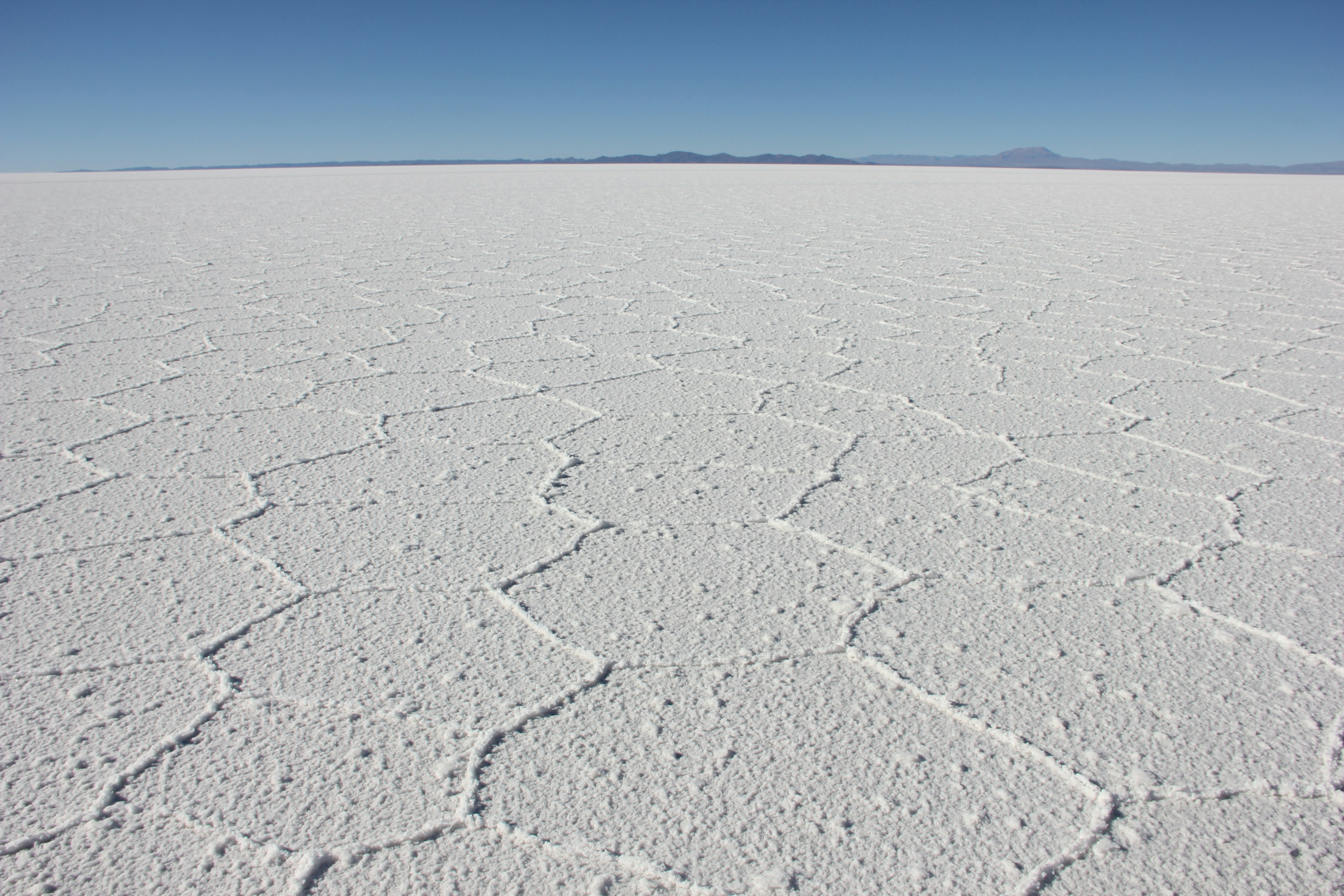a vast expanse of white sand with a blue sky in the background