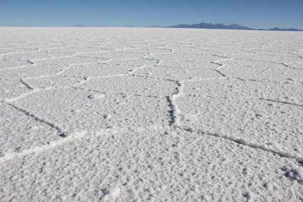 a vast expanse of white snow with mountains in the distance