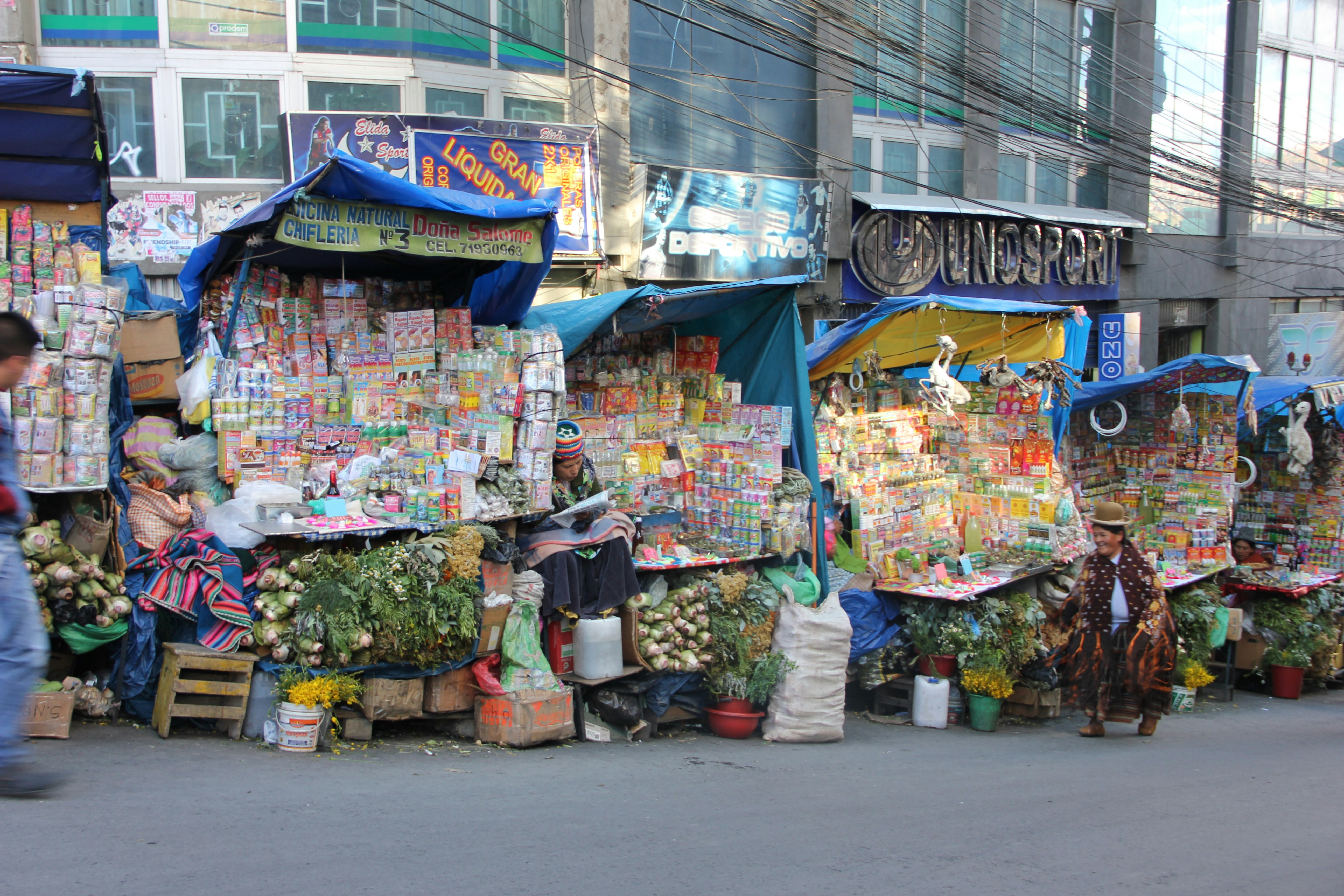 a man walking down a street next to a market