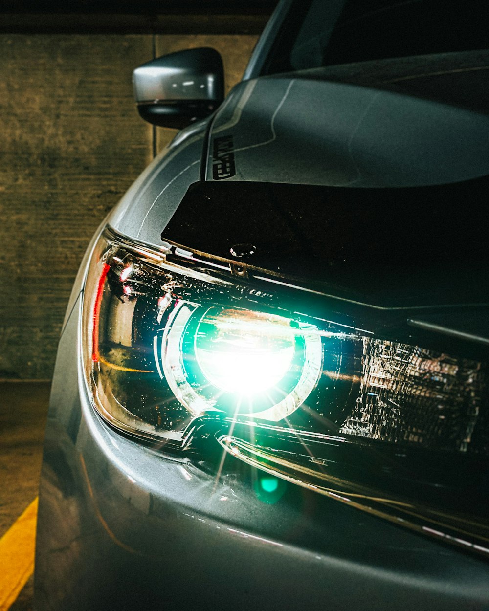 a close up of a car's headlight on a street