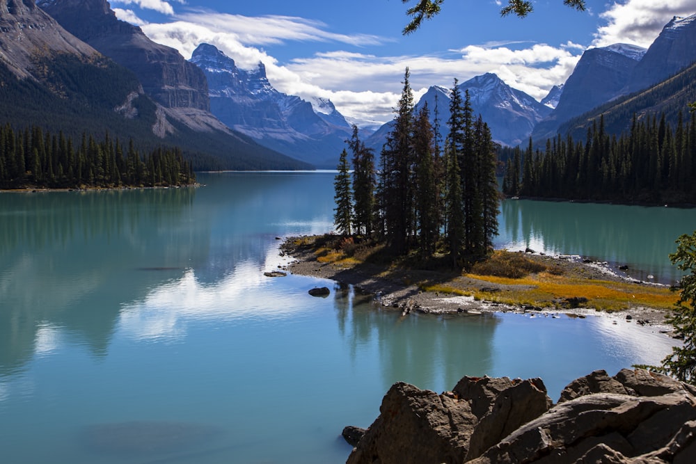 a lake surrounded by mountains and pine trees