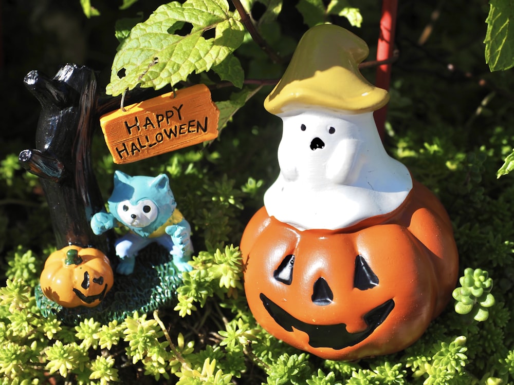 Un par de decoraciones de Halloween sentadas en la cima de un exuberante campo verde