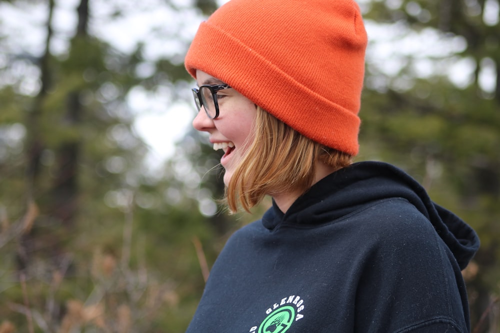 a woman in a black hoodie and a orange hat