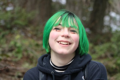 a girl with green hair and a black hoodie