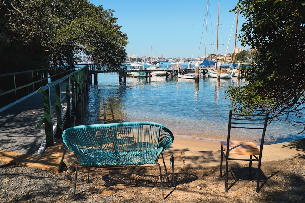 a couple of chairs sitting next to a body of water