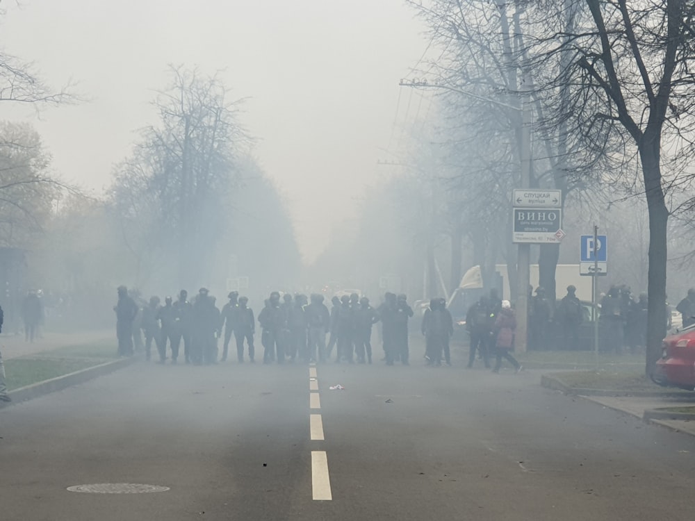 a group of people standing on the side of a road