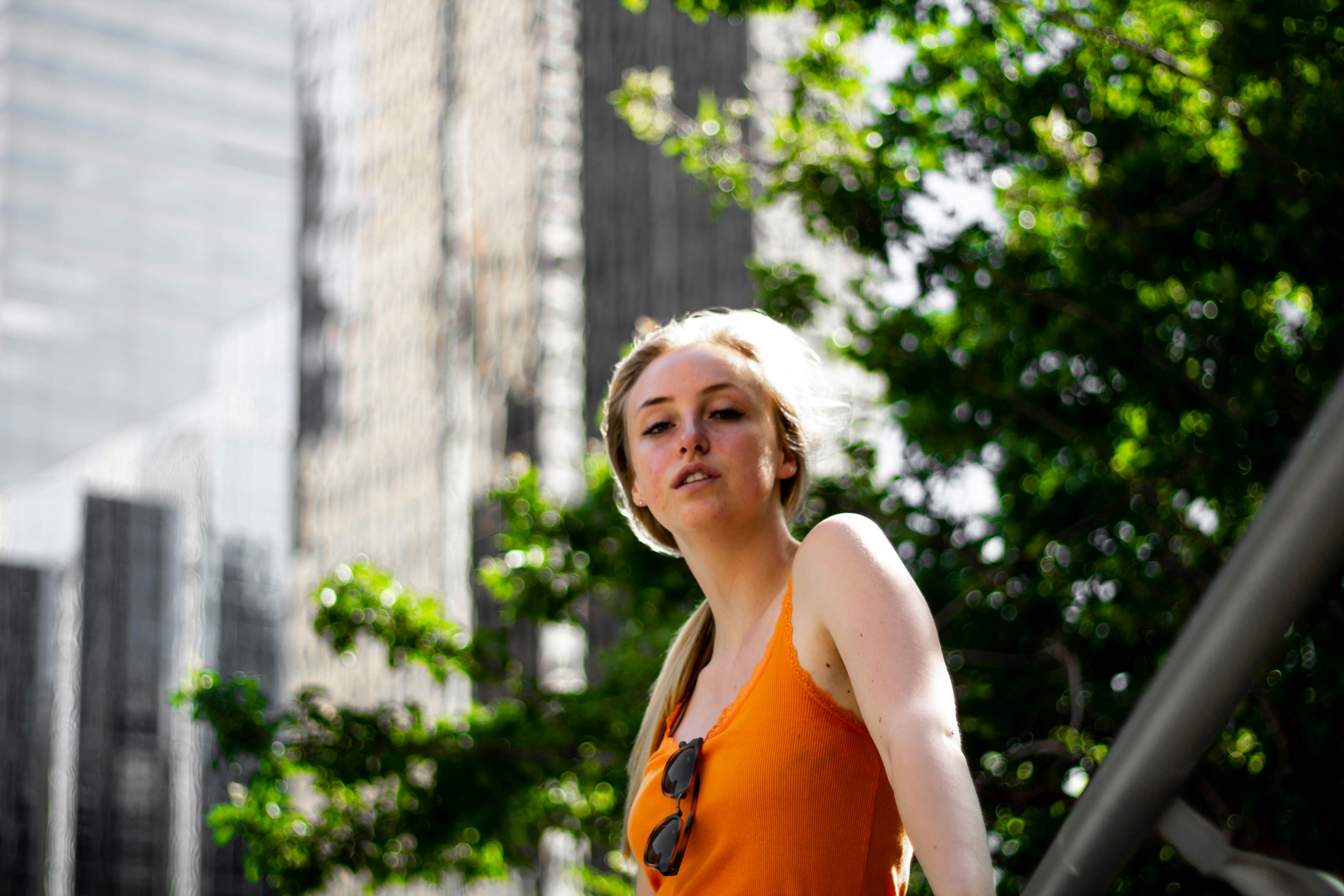 a woman in an orange top is walking down the street