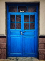 A sturdy steel security door painted deep blue, standing strong on a suburban home.