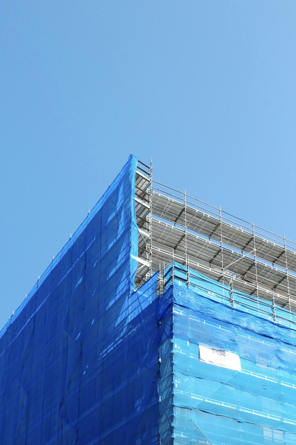 a large blue building under construction with scaffolding