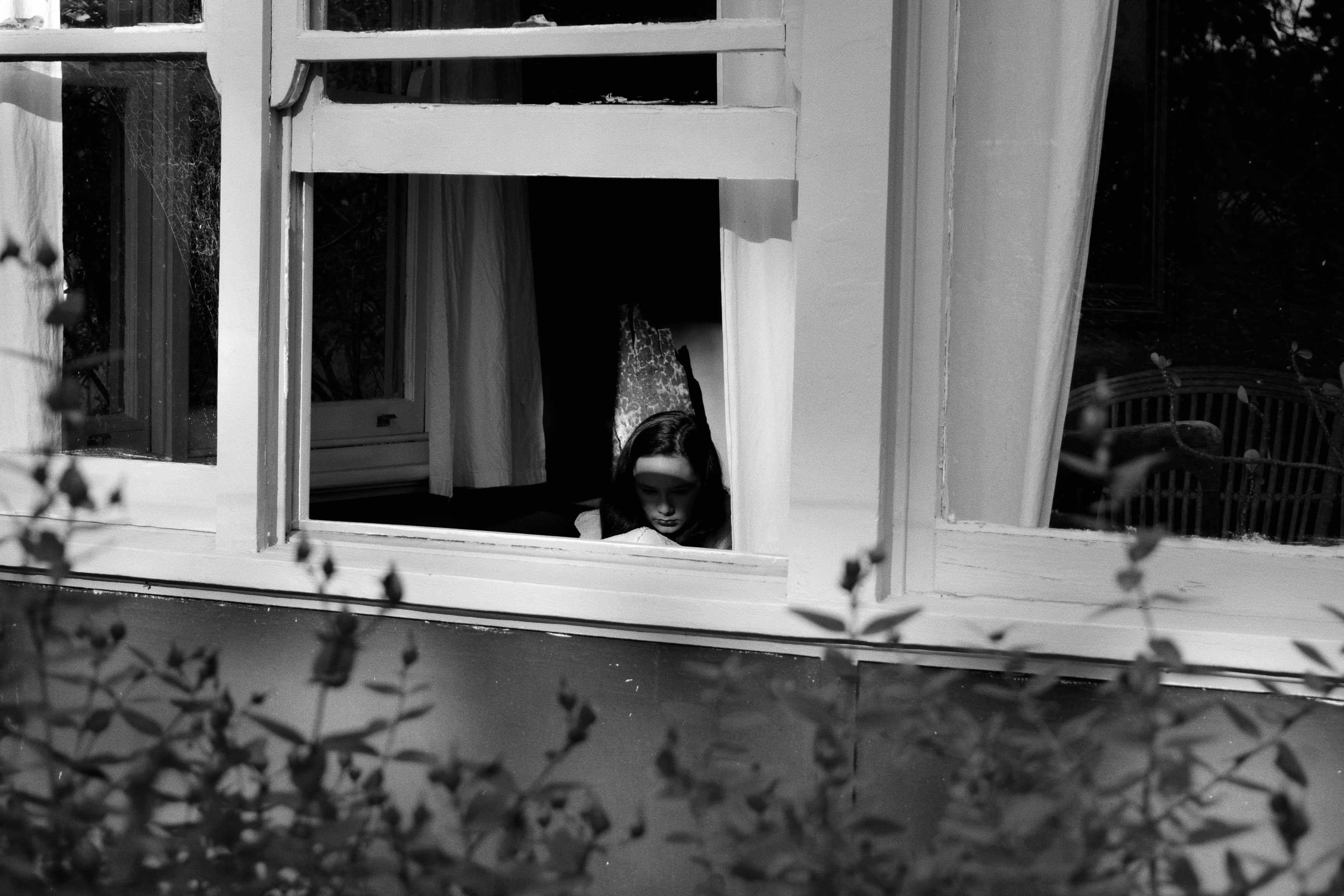 a woman is looking out of a window