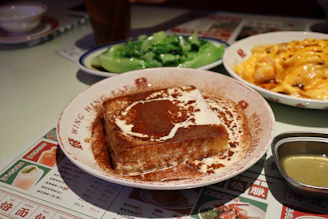 a table topped with plates of food and a bowl of macaroni and cheese